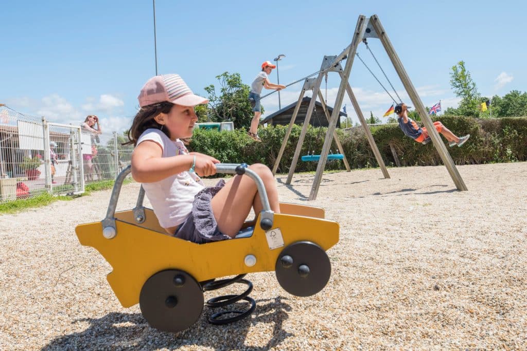Enfant qui s'amuse à l'air de jeux pour enfants du camping Soleil Levant à Meschers